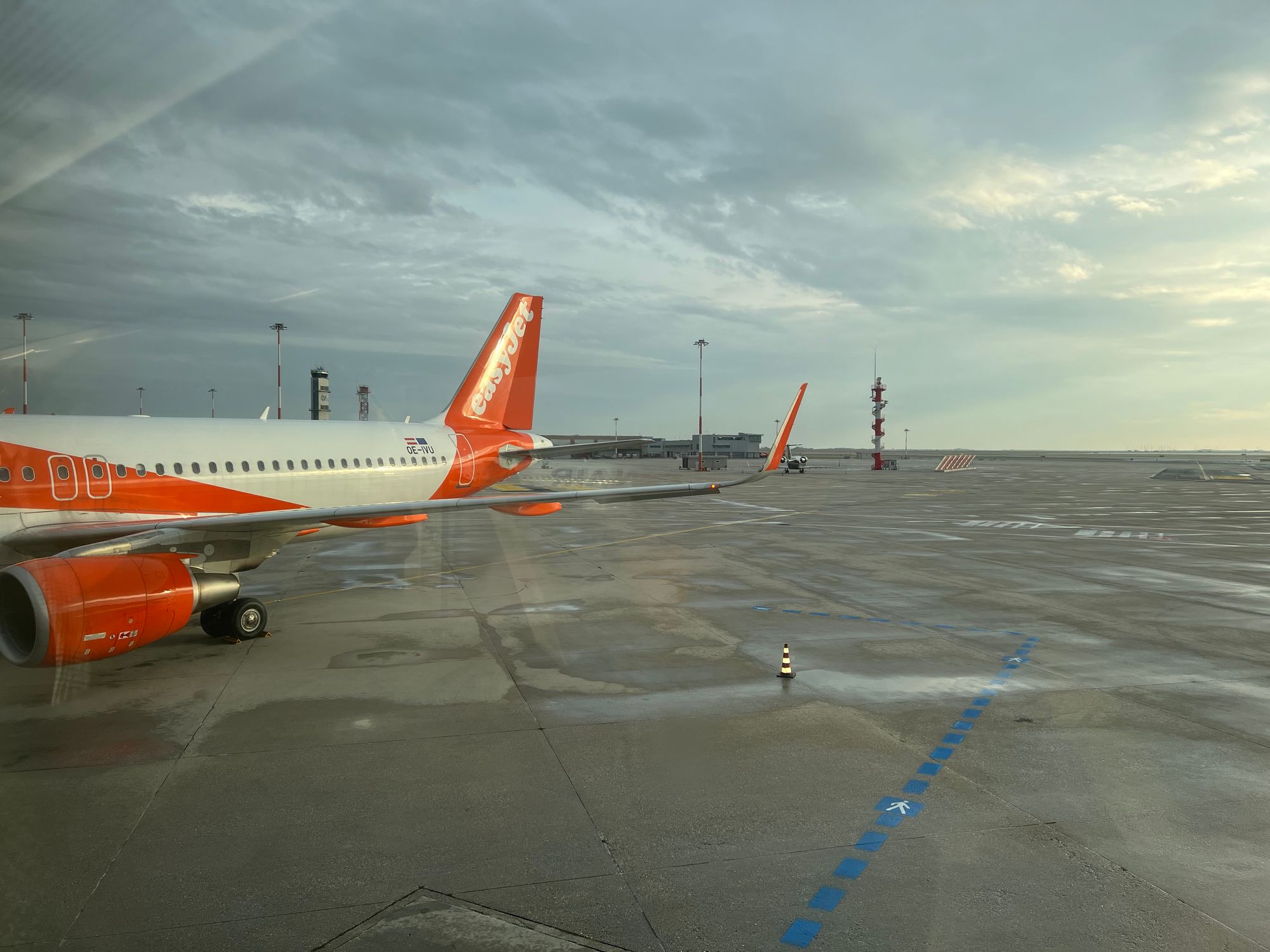 Looking out of boarding ramp at airport towards an Airplane on the tarmac. 